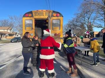 Students and staff at St. Pius X Elementary School fill  school bus with non-perishable food items, December 5, 2024. (Photo by Maureen Revait) 