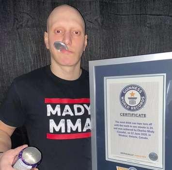 Chucky Mady of Windsor displays his Guinness Book of World Records certificate for opening beer cans with his mouth. Photo courtesy Chucky Mady/Instagram.