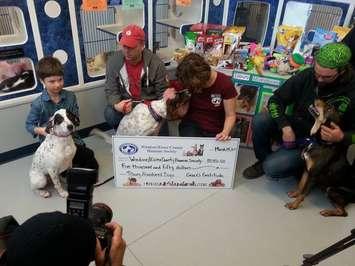 The dogs rescued earlier this year in Tilbury pose with a cheque for the Windsor-Essex County Humane Society (Photo courtesy of Karen Newman).
