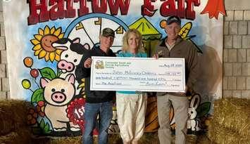 From left, Phillip Stannard, Cathy Mombourquette of the John McGivney Children's Centre, and Mark Stannard with the fundraising cheque at the Harrow Fair, August 28, 2025. Photo courtesy John McGivney Children's Centre.