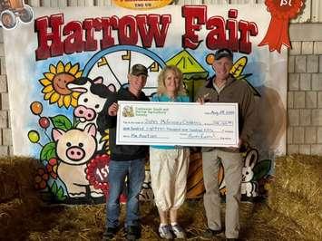 From left, Phillip Stannard, Cathy Mombourquette of the John McGivney Children's Centre, and Mark Stannard with the fundraising cheque at the Harrow Fair, August 28, 2025. Photo courtesy John McGivney Children's Centre.