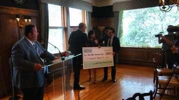 Windsor Mayor Drew Dilkens accepts a check from the Windsor Essex Community Foundation as TWEPI CEO Gordon Orr looks on at the Canadian Club Brand Centre in Windsor, August 11, 2017. Photo by Mark Brown, Blackburn News. 