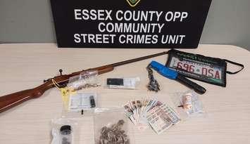 Suspected illicit drugs, a weapon, and other items from a raid in Leamington on December 10, 2024, are displayed. Photo courtesy Ontario Provincial Police.