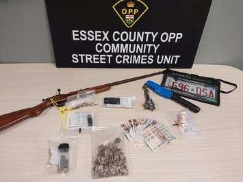 Suspected illicit drugs, a weapon, and other items from a raid in Leamington on December 10, 2024, are displayed. Photo courtesy Ontario Provincial Police.