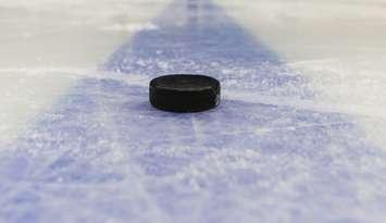 Detail blue line with puck on ice hockey rink. © Can Stock Photo / fotoduki