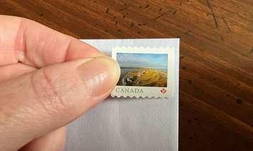 A stamp being placed on a letter. (Photo by Miranda Chant, Blackburn Media)