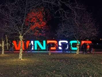 Visitors to Bright Lights Windsor congregate near a light display at Jackson Park, December 4, 2021. Photo by Mark Brown/WindsorNewsToday.ca.