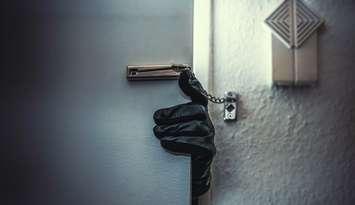 Masked burglar with crowbar breaking and entering into a victim's home.  © Can Stock Photo / audioundwerbung