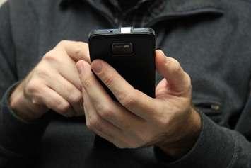 A person on a smartphone. File photo courtesy of © Can Stock Photo / portosabbia