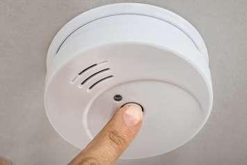 A person testing a smoke alarm. File photo courtesy of © Can Stock Photo / AndreyPopov