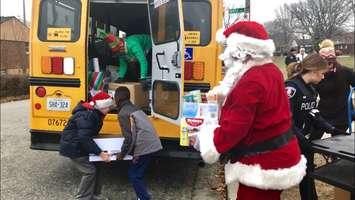 Students from St. James Catholic School in Windsor Ontario load in donations for their annual Santa's School Bus Toy Drive on December 12, 2018. (Photo by Allanah Wills)