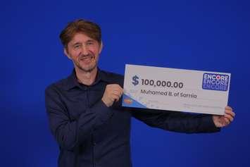 Muhamed Becirspahic show off his big cheque after claiming an ENCORE win. Photo courtesy of OLG.