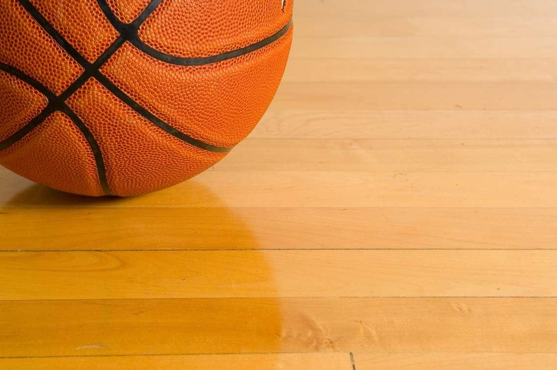 A basketball on a gym floor. © Can Stock Photo / mflippo