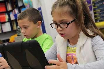 A girl using an iPad tablet. (Photo by Pxfuel)