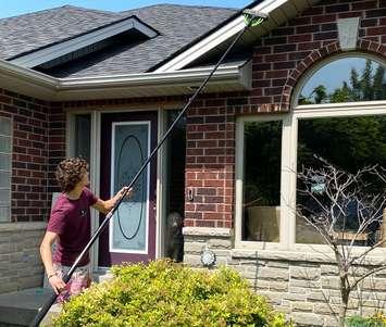 Ryan Reid of Crystal Clean Windows in Amherstburg cleans the exterior of a home for a customer. Photo submitted by the Small Business and Entrepreneurship Centre.