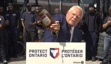 Premier Doug Ford dumps a bottle of Crown Royal during a news conference, September 2, 2025. via YouTube. 