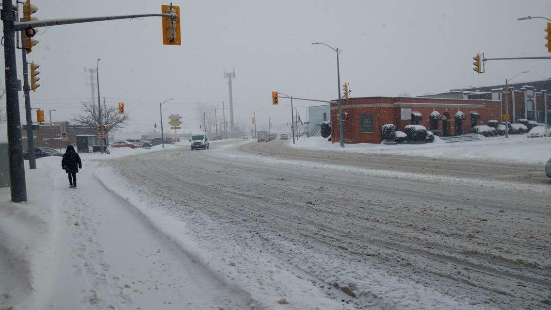 A pedestrian walks along Wyandotte St E in Windsor during a snowfall on February 9, 2018. Photo by Mark Brown/Blackburn News.