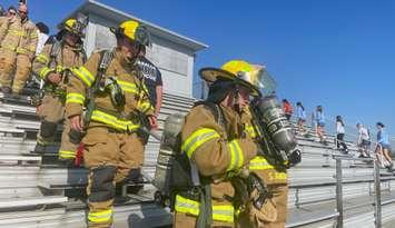 LaSalle fire fighters climb the bleachers and St. Thomas of Villanova High School to mark the anniversary of 9/11. 