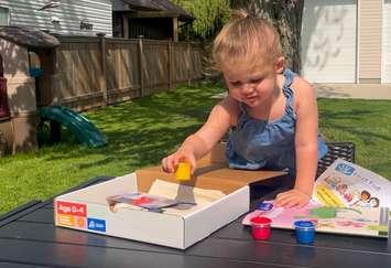 Claire Allen opens a Lambton County Library Summer Reading Challenge registration kit - June 17/24 (Photo courtesy of Lambton County Library)