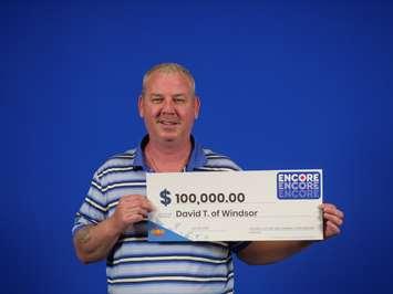 David Turner of Windsor displays his $100,000 prize cheque for winning the OLG encore game, at the OLG Prize Centre in Toronto, June 30, 2022. Photo provided by OLG.