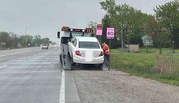 A vehicle is towed from the site of a traffic stop on Highway 3 in Tecumseh, May 13, 2025. Photo courtesy OPP West Region/X.