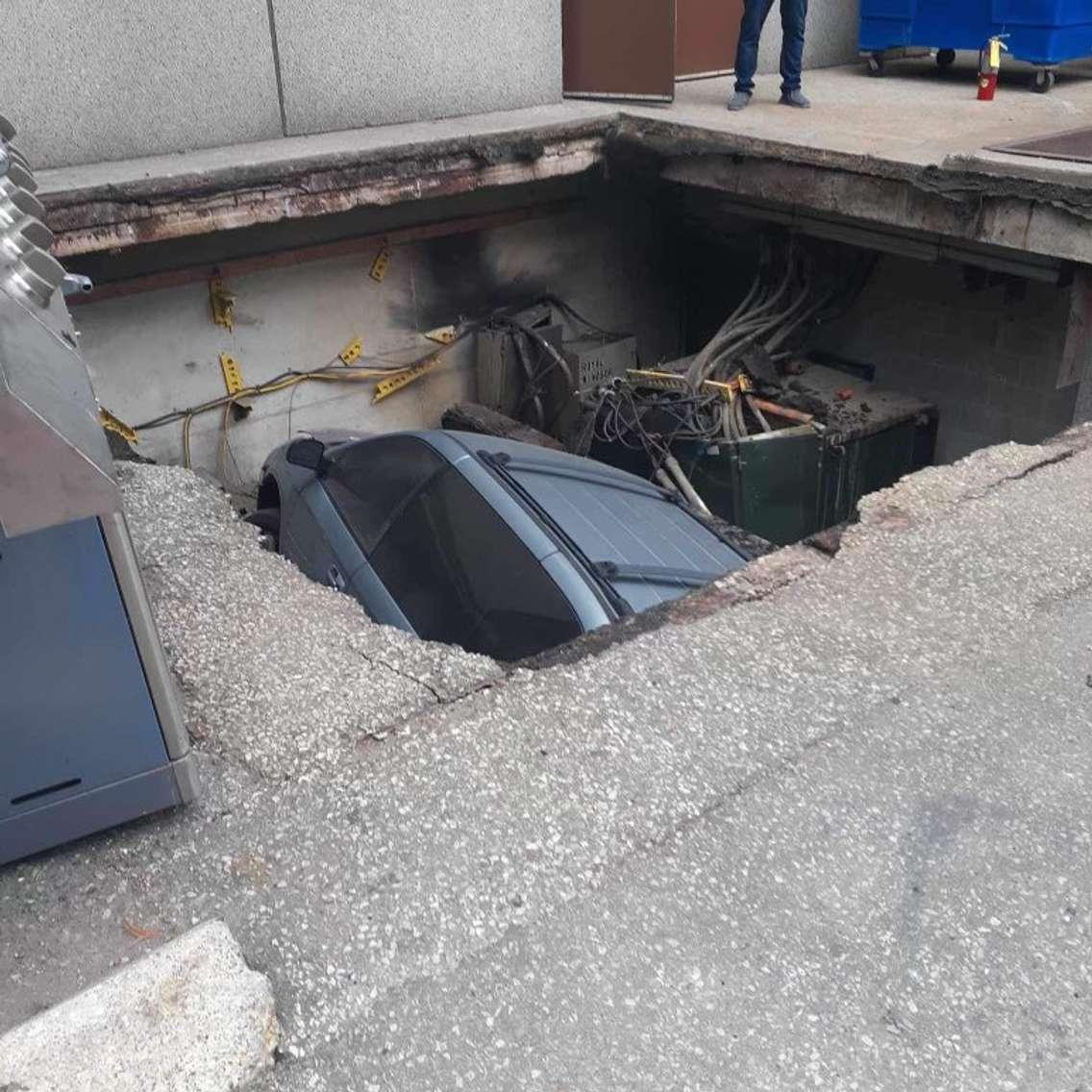 A vehicle inside a sinkhole in downtown Windsor. September 19, 2023. Photo via @drewdilkens on X.  