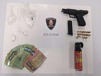 An assortment of cash, weapons, and suspected drugs are displayed on September 29, 2023. Photo provided by Windsor Police.