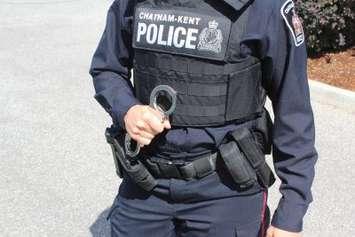 Police officer presenting handcuffs. (Photo by Greg Higgins)