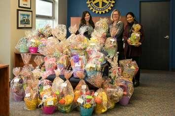 Representatives from the Rotary Club of Windsor and Children First pose alongside 40 Easter baskets. Photo courtesy of the Rotary Club of Windsor.