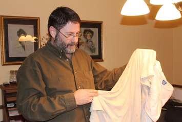 Sean Moore holding up a blood-stained tee-shirt that he says he wore in a Syrian prison. February 10, 2018. (Photo by Sarah Cowan Blackburn News Chatham-Kent).  