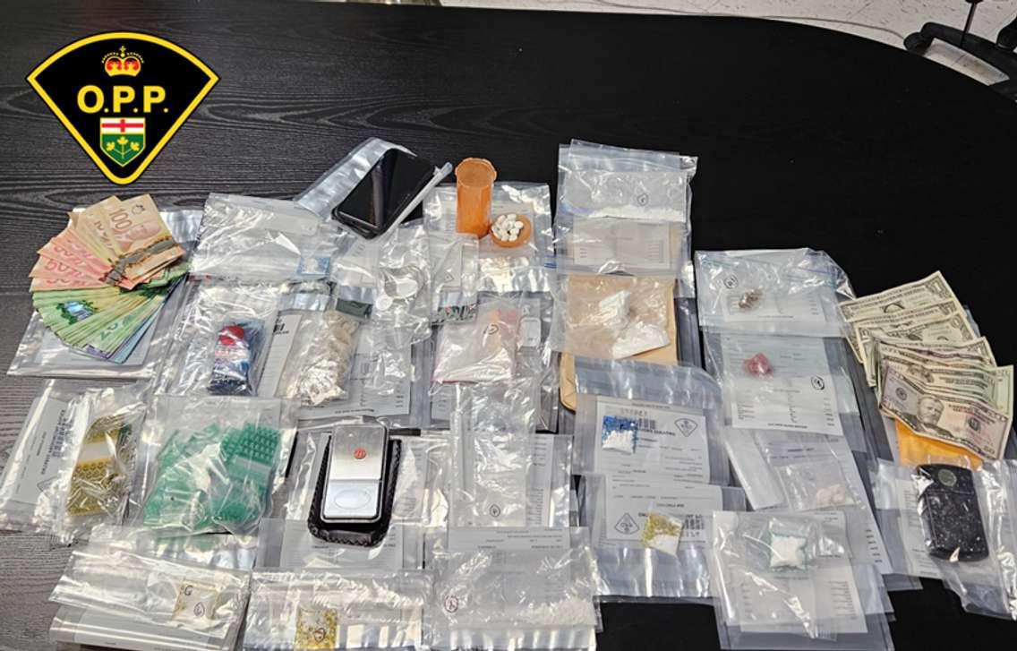 An assortment of suspected drugs, cash, and other items is displayed by Ontario Provincial Police on July 14, 2023. Photo provided by Ontario Provincial Police.