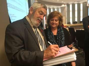 Lakeshore Mayor Tom Bain (L) in Council Chambers at the Essex Civic Centre on November 5, 2014 signing a petition handed out by former Kingsville Deputy Mayor Tamara Stomp (R) opposing the pending closure of the obstetrics ward at Leamington District Memorial Hospital. (Photo by Ricardo Veneza)
