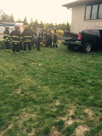 Emergency crews tend to a patient following a collision between a pickup truck and a house in Leamington on Oct 23, 2016 (Photo courtesy of Leamington Fire)