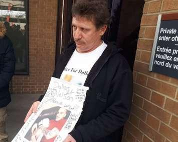 David Nelson Sr., father of shooting victim Dallas Nelson, shows a photo of his son outside the courthouse in Windsor, April 2, 2019. Photo by Mark Brown/Blackburn News.