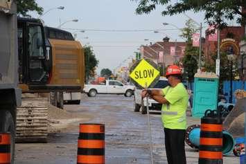 A flagger looks on as construction on Wyandotte St. E. between Devonshire Rd. and Gladstone Ave. continues.  (Photo by Adelle Loiselle.)