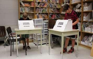 Grade six students Matteo Asta (left) and Molly Campbell (right) at St. Angela Catholic Elementary School take part in Ontario's Student Vote, June 11, 2014. (photo by Mike Vlasveld)