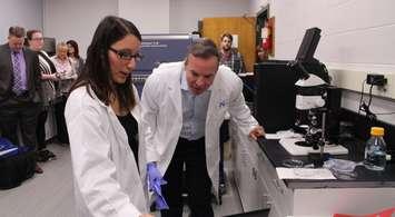 PhD Candidate Rosa-Maria Ferraiuolo demonstrates new equipment to Kevin Laforet, Regional President of Caesars Windsor, May 23, 2017 (photo by Maureen Revait) 