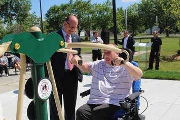 Windsor Mayor Drew Dilkens (left) watches Huron Lodge Residents Council Vice President Oskar Rauscher (right) use new exercise equipment outside of the long-term care home, June 21, 2017. (Photo by Mike Vlasveld)