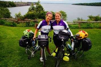 Sarah French (left) and Mary Fehr (right) pose for a photo by their bikes as part of their cross-country ride. (Photo courtesy MEDA Bike To Grow via Facebook)