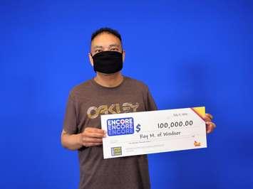 Roy Macatangay of Windsor shows off his $100,000 cheque at the OLG Prize Centre in Toronto on July 17, 2020. Photo provided by OLG.