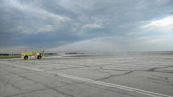 A fire truck waters down a taxiway at Windsor Airport on June 16, 2017 (Photo by Mark Brown/Blackburn News)
