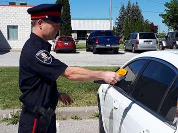 Windsor Police Constable Andy Drouillard demonstrates the infrared thermometer on a parked car at Ground Effects in Windsor on June 14, 2018. Photo by Mark Brown/Blackburn News.