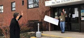 Rotarian Michael John Kooy surprises Inn of the Good Shepherd Executive Director Myles Vanni with a cheque from the Rotary Club of Sarnia for $4000 – while observing social distancing. March 2020. (Photo provided by the Rotary club)