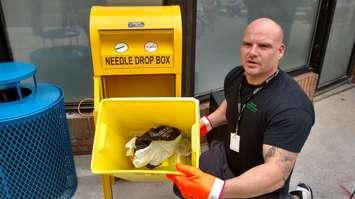 Jeremy Wigfield of Street Health shows how the new sharps disposal box works on Pelissier in Windsor, September 13, 2017. Photo by Mark Brown, Blackburn News.