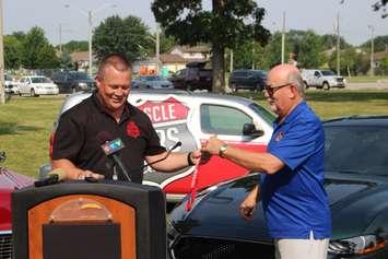 Dave Laitinen of Muscle Cars and Classics presents Tecumseh Mayor Gary McNamara with the first official lanyard for the Cream of the Crop invitational, which will take place during the upcoming Tecumseh CornFest, Lacasse Park, July 29, 2019. Photo by Mark Brown/Blackburn News.