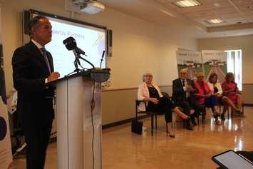 Jim Inglis, co-chair of ProsperUS, presents its first milestone report, as from left, Hotel-Dieu Grace Healthcare CEO Janice Kaffer, Essex County Warden Gary McNamara, Leamington Mayor Hilda MacDonald, Windsor-Essex Childrens Aid Society COO Terry Johnson and United Way of Windsor-Essex County CEO Lorraine Goddard listen, July 24, 2019. Photo by Mark Brown/Blackburn News.