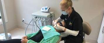Christine Fairbairn providing a dental checkup for a patient. September 2017. (Photo courtesy of Bright Smiles Community Dental Hygiene via Facebook)