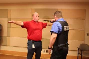 Security staff demonstrate metal wand detectors at Windsor Regional Hospital, September 8, 2017. (Photo by Maureen Revait) 