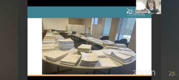 Windsor Regional Hospital COO and Chief Nursing Officer Karen Riddell (inset), shows off the high amount of paperwork used for recordkeeping while a cyberattack affected the hospital's computer systems, December 7, 2023. Screenshot courtesy WRHWeCare/YouTube.