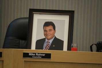 A framed photograph of late Tecumseh councillor Mike Rohrer sits at his seat on council at the regular meeting on July 12, 2016. (Photo by Ricardo Veneza)